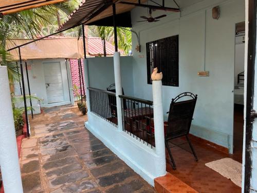 a balcony of a house with a chair on it at Oceanic guest house in Canacona