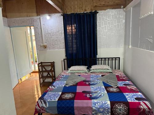 a bedroom with a bed with a quilt on it at Oceanic guest house in Canacona