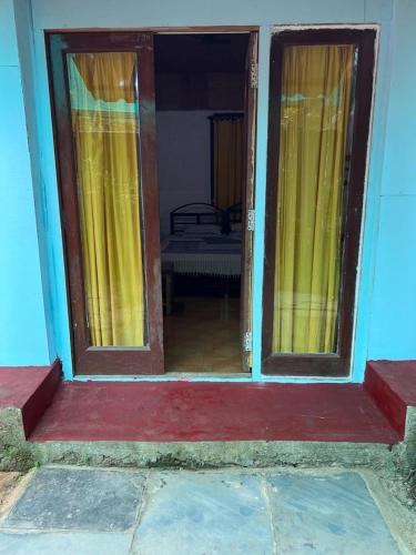 eine offene Tür zu einem Zimmer mit gelben Vorhängen in der Unterkunft Oceanic guest house in Canacona