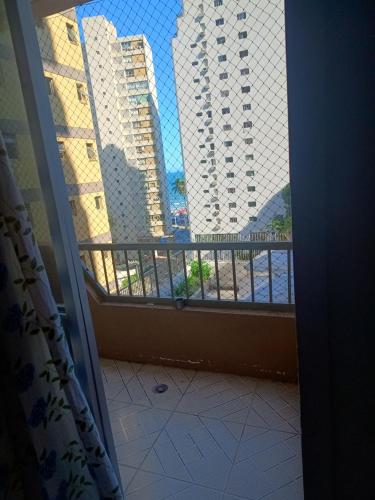 a room with a balcony with a view of buildings at A casa azul em frente a praia ambiente familiar in Guarujá