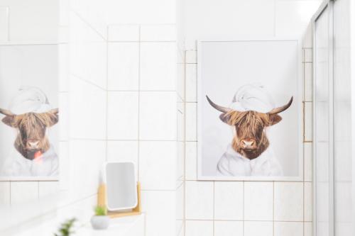 two pictures of a cow on the wall in a bathroom at Apartments an der Oper - Innenstadt - Zentral - Küche - Wifi - Powered by Ko-Living in Halle an der Saale