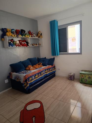 a bedroom with a bed and stuffed animals on the wall at A casa azul em frente a praia ambiente familiar in Guarujá