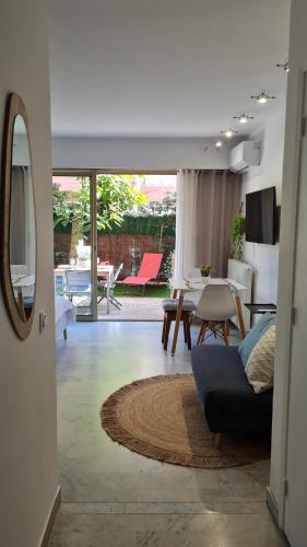 a living room with a blue couch and a table at Studio Sun-Beach avec parking et jardin - 500m des plages de Juan Les Pins in Antibes