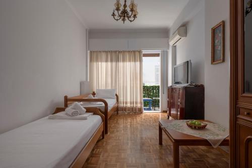 アテネにあるΔΙΠΛΑ ΣΕ ΜΕΤΡΟ , ΚΟΝΤΑ ΣΤΗΝ ΑΚΡΟΠΟΛΗのベッド2台とテーブルが備わるホテルルームです。
