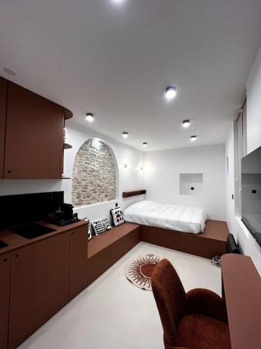 une chambre avec un lit et une chaise dans une pièce dans l'établissement The Studio Family - Le Terracotta, à Dijon