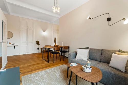 un salon avec un canapé et une table dans l'établissement Nice Renting - DABRAY - Chic & Spacious Apartment in the Heart of Nice - Prime Location Near Attractions, à Nice