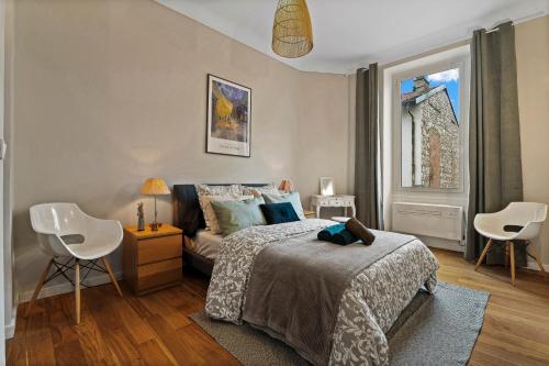 une chambre avec un lit et deux chaises et une fenêtre dans l'établissement Nice Renting - DABRAY - Chic & Spacious Apartment in the Heart of Nice - Prime Location Near Attractions, à Nice