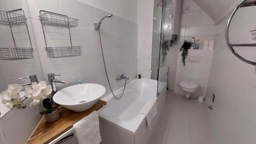 ヴェスプレームにあるOrchidea Veszprém Apartmanの洗面台とトイレを備えた白いバスルーム