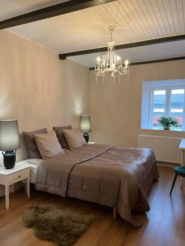 ein Schlafzimmer mit einem großen Bett und einem Kronleuchter in der Unterkunft Dragsgaard Herregård 