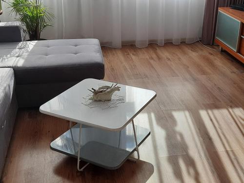 a living room with a couch and a table at Apartament pod Dębem in Dąbki