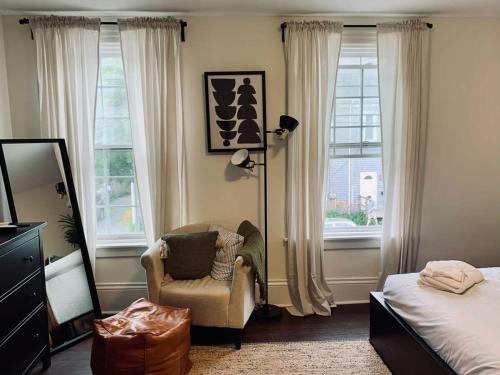 een slaapkamer met een stoel, een bed en ramen bij Pet-Friendly Lovely Studio #2, Balcony in Halifax