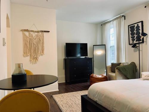 a bedroom with a bed and a table and a tv at Pet-Friendly Lovely Studio #2, Balcony in Halifax