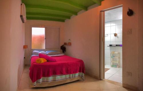 1 dormitorio con 1 cama con manta roja en Alma da Praia, en Ubatumirim