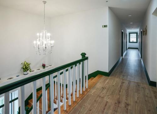 einen Flur mit einer Treppe und einem Kronleuchter in der Unterkunft Catrinandes - Retreat Center in Tondela