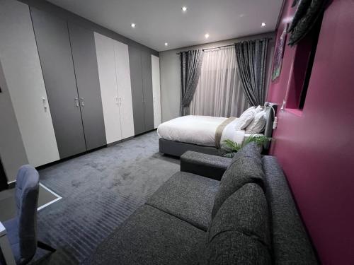 a hotel room with a bed and a couch at The Raz in Harrismith