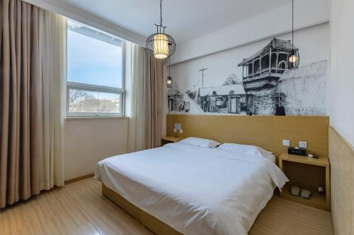 a bedroom with a large bed and a window at Happy Dragon Alley Hotel-In the city center with big window&free coffe, Fluent English speaking,Tourist attractions ticket service&food recommendation,Near Tian Anmen Forbiddencity,Near Lama temple,Easy to walk to NanluoAlley&Shichahai in Beijing