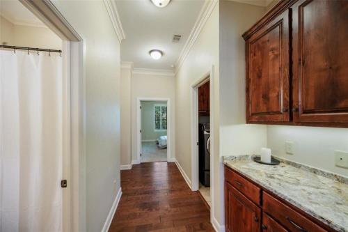 a kitchen with a wooden cabinet and a hallway at Grapevine Luxury Home in Grapevine