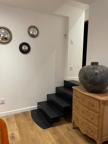 a room with black stairs and a vase on a dresser at La Fleur de Sel in Honfleur