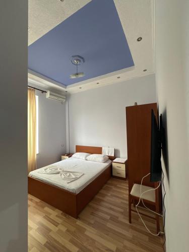 um quarto com uma cama e um tecto azul em Haliti hotel em Kukës