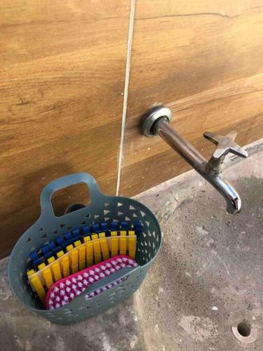 a basket of colored toothbrushes sitting next to a door at Apartamento C na vila-alta em Crato in Crato