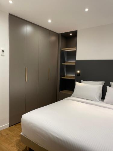 a bedroom with a large white bed and a closet at La Fleur de Sel in Honfleur