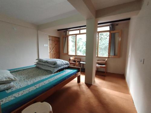 - une chambre avec 2 lits et une fenêtre dans l'établissement Himalaya View, à Rānīkhet