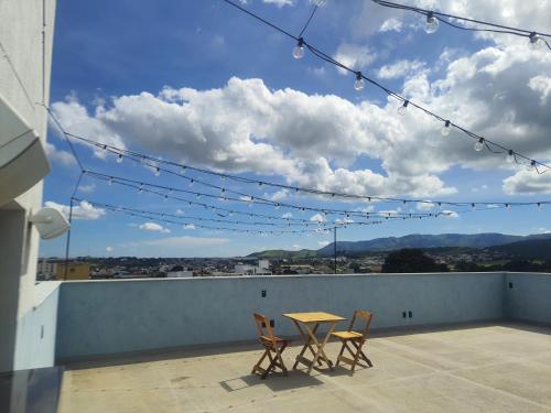 a table and chairs on a balcony with a view at Apart-hotel Theotókos Flats in Piumhi