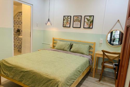 a bedroom with a bed and a table and a mirror at STAY hostel 2 - 350m from the ferry in Rach Gia