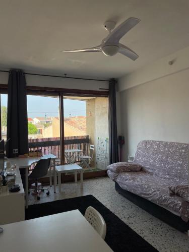 un salon avec un canapé et un ventilateur de plafond dans l'établissement Studio cosy cours Sextius, à Aix-en-Provence