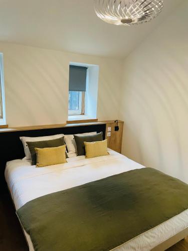 a bedroom with a large white bed with yellow pillows at La Fleur de Sel in Honfleur
