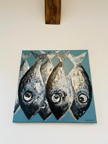 a painting of three fish hanging on a wall at La Fleur de Sel in Honfleur