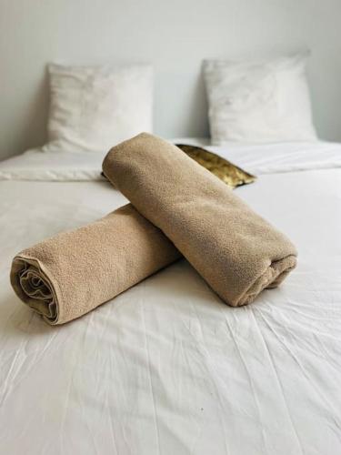 une pile de serviettes posée sur un lit dans l'établissement Kay DouDou 60m2 - 5 min Aéroport - Navette - Parking, à Bonlier