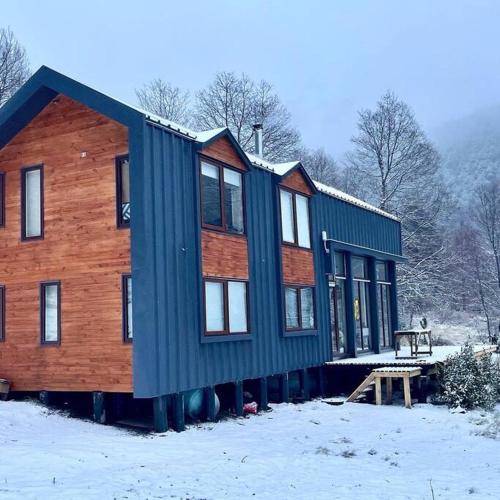 a large house in the snow with a wooden at Refugio entre Montañas - Malalcahuello in Malalcahuello
