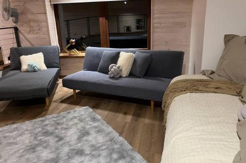 a living room with a blue couch and a bed at Refugio entre Montañas - Malalcahuello in Malalcahuello