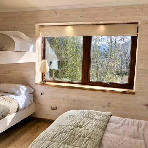 a bedroom with a window and a bed in it at Refugio entre Montañas - Malalcahuello in Malalcahuello