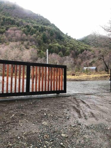 a gate on the side of a road with a mountain at Refugio entre Montañas - Malalcahuello in Malalcahuello