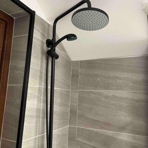 a shower with a shower head in a bathroom at Refugio entre Montañas - Malalcahuello in Malalcahuello