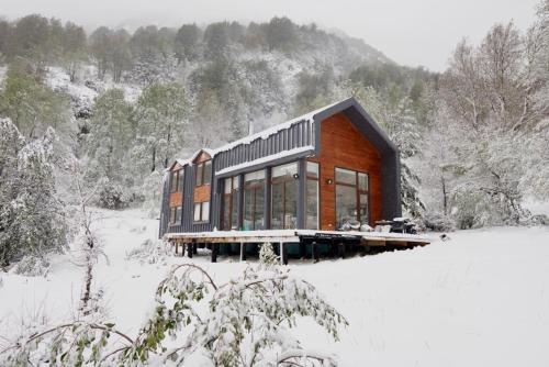 a house in the middle of a snow covered field at Refugio entre Montañas - Malalcahuello in Malalcahuello