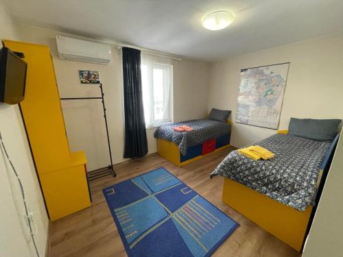 a small room with two beds and a television at NiDo Cozy 3BR Apartment Kapana Top Center in Plovdiv