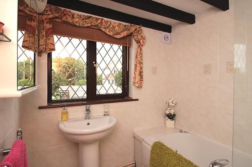 a bathroom with a sink and a bath tub and a window at Mellowvean in St. Agnes