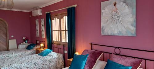 um quarto com 2 camas e paredes roxas em Casa Roble B&B em Cómpeta