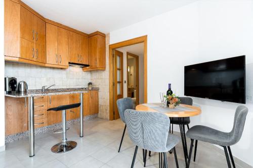 a kitchen with a table and chairs and a television at Apartament z widokiem na morze 250 m od plaży in Torrevieja