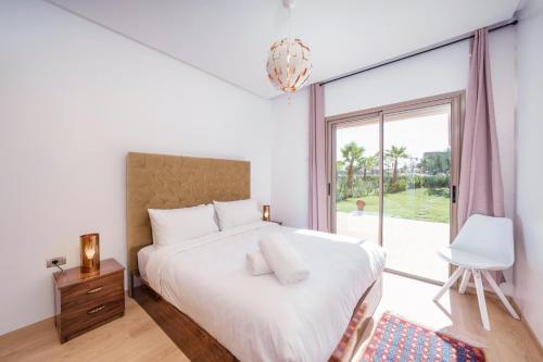 a bedroom with a bed and a large window at Apart Confort Front Pool-Garden in Marrakesh
