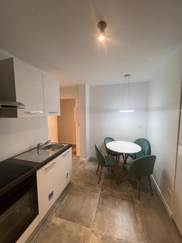 a kitchen with a table and chairs and a table and a table and chairsktop at Spacieux appartement Paris/Stade De France/CDG in La Courneuve