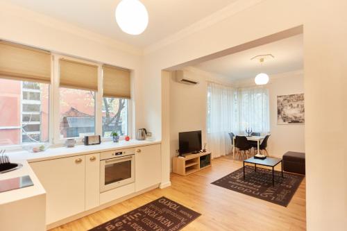 uma cozinha e sala de estar com um sofá e uma mesa em Vitosha Blvd Apt Steps from NDK em Sófia