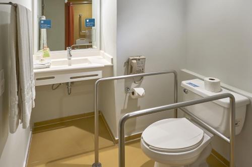 La salle de bains est pourvue de toilettes, d'un lavabo et d'un miroir. dans l'établissement City Express Junior by Marriott Toluca Zona Industrial, à Toluca