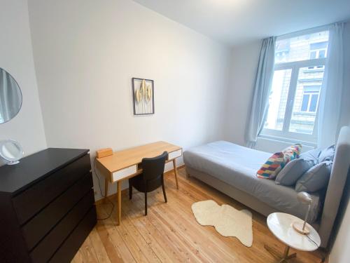 a bedroom with a bed and a desk and a table at New Cozy Apartments In Porte de HAL in Brussels