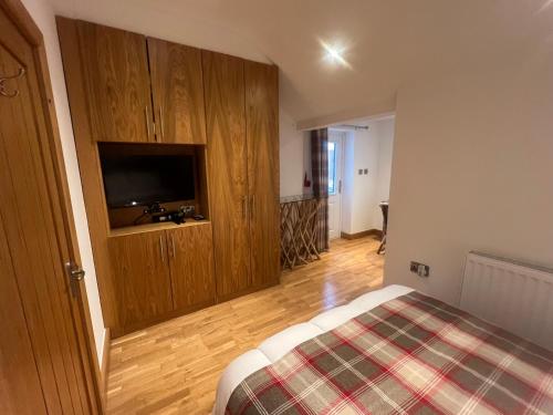 a bedroom with a bed and a flat screen tv at Canalside Rooms in Taunton