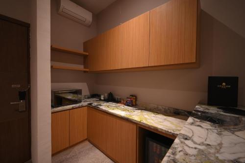 a kitchen with wooden cabinets and a counter top at Double Nine Hotel in Malino