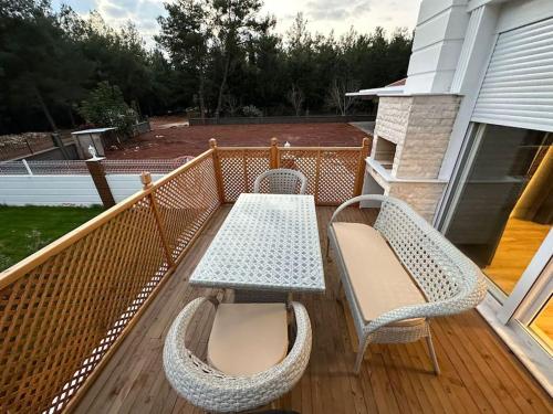 a table and two chairs on a deck at Deluxe Villa in Forest in Dosemealti